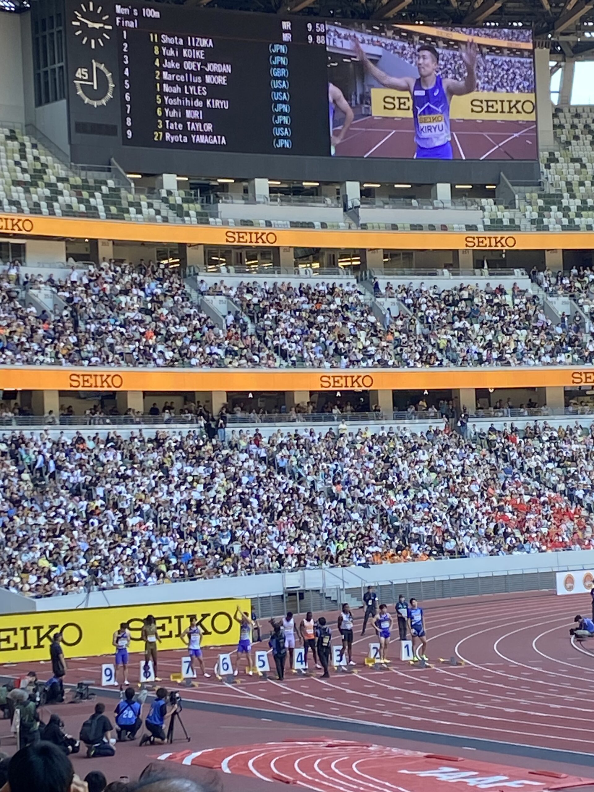 男子100m決勝前、大型ビジョンに映る選手紹介